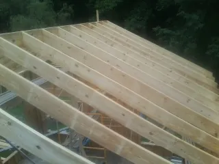 New roof rafters set over an addition before sheathing in Harrison